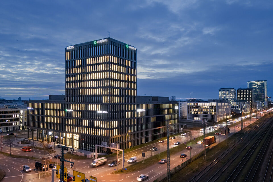 Beleuchteter Gebäudekomplex im Glücksteinquartier Mannheim in der Abenddämmerung